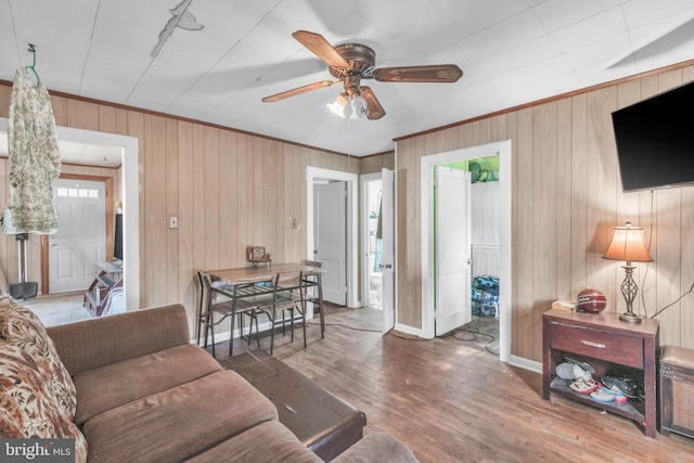 living room with wooden walls, ceiling fan, and dark hardwood / wood-style floors