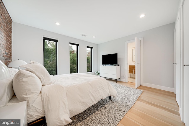 bedroom featuring light wood-type flooring and connected bathroom