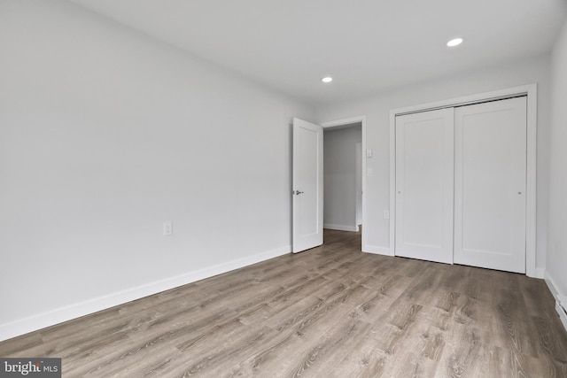 unfurnished bedroom with light hardwood / wood-style floors and a closet