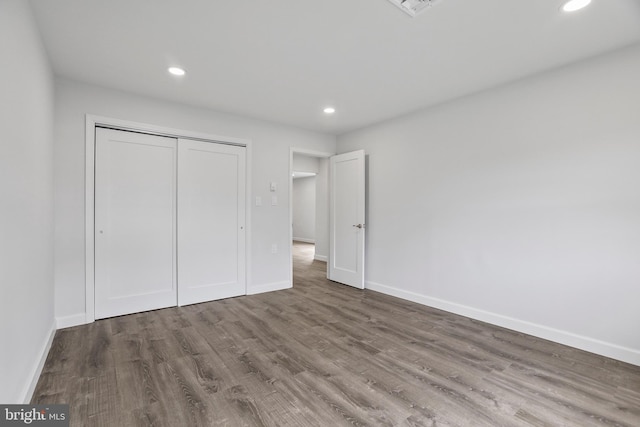 unfurnished bedroom featuring a closet and hardwood / wood-style flooring