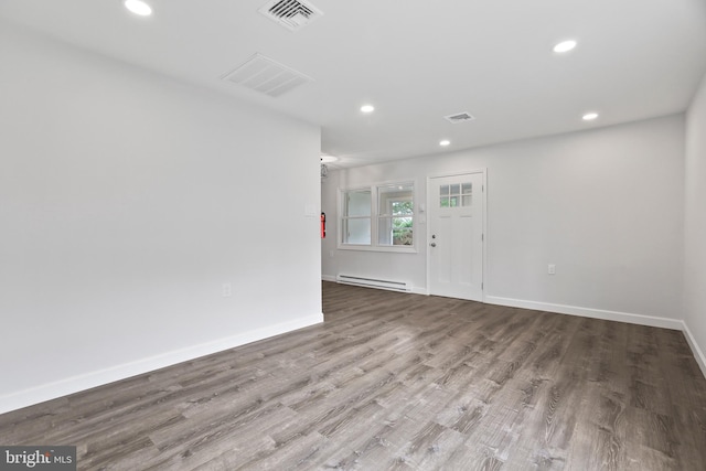 spare room with baseboard heating and light wood-type flooring