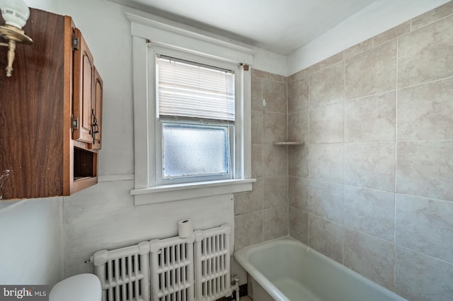 bathroom featuring radiator heating unit, toilet, and a bathing tub