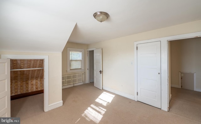 unfurnished bedroom with light carpet and vaulted ceiling