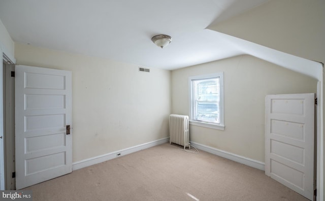 bonus room with lofted ceiling, light colored carpet, and radiator heating unit