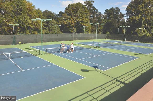 view of tennis court featuring basketball hoop