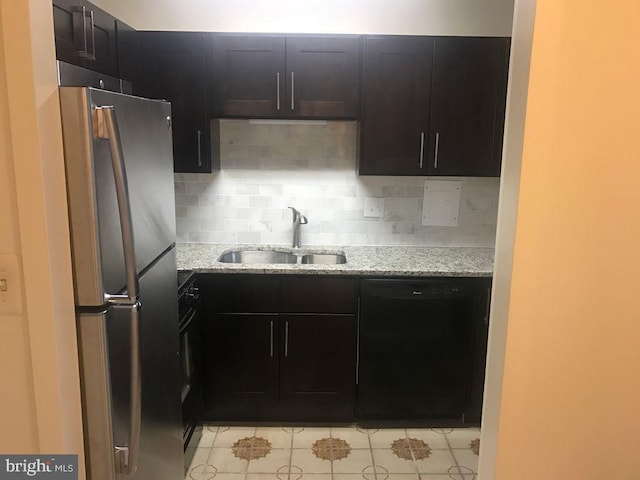 kitchen featuring sink, backsplash, light stone counters, and black appliances