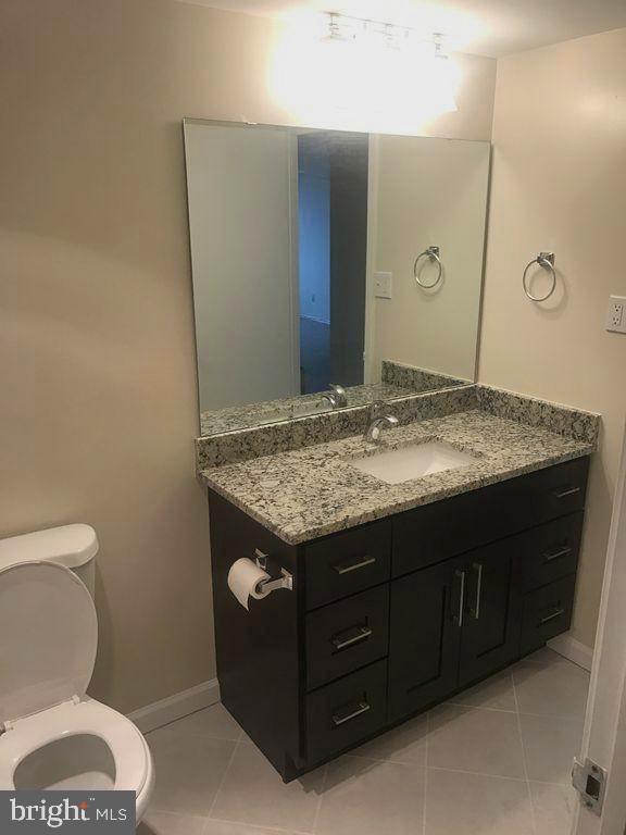 bathroom with tile patterned flooring, vanity, and toilet