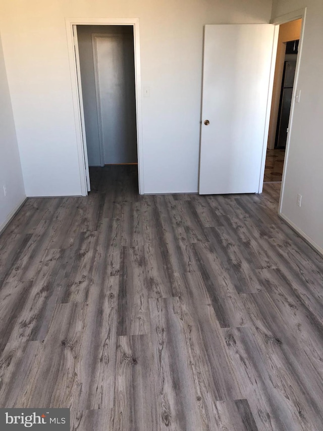 unfurnished bedroom featuring dark hardwood / wood-style flooring and a closet