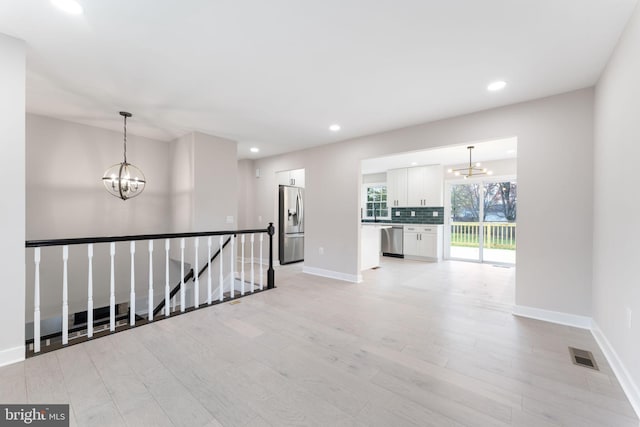 interior space featuring light hardwood / wood-style floors and an inviting chandelier