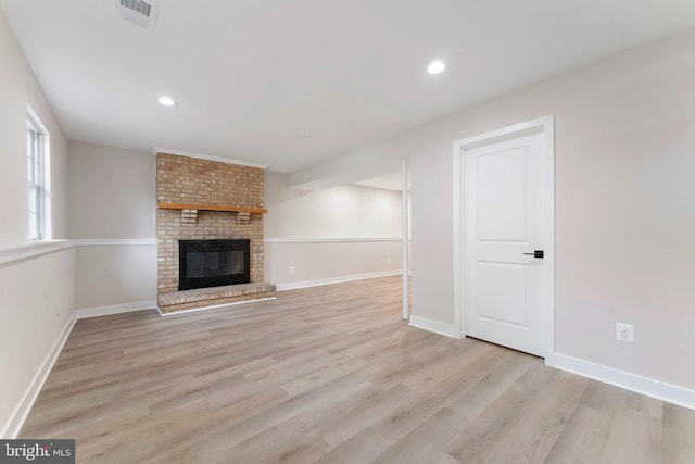 unfurnished living room with a fireplace and light hardwood / wood-style flooring