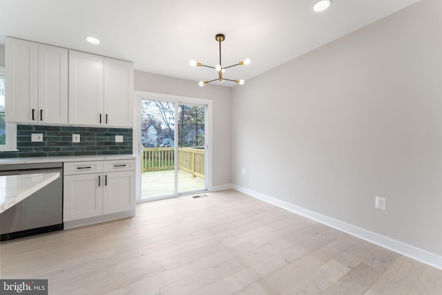 kitchen featuring white cabinetry, dishwasher, a notable chandelier, pendant lighting, and light hardwood / wood-style floors