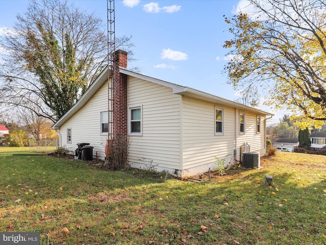 view of home's exterior with a lawn and central AC