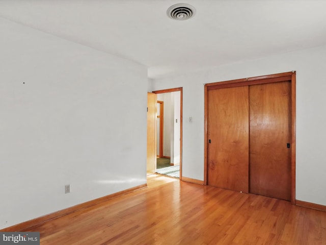 unfurnished bedroom with a closet and light wood-type flooring