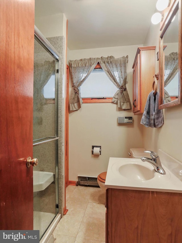 bathroom featuring tile patterned flooring, vanity, toilet, and a shower with shower door