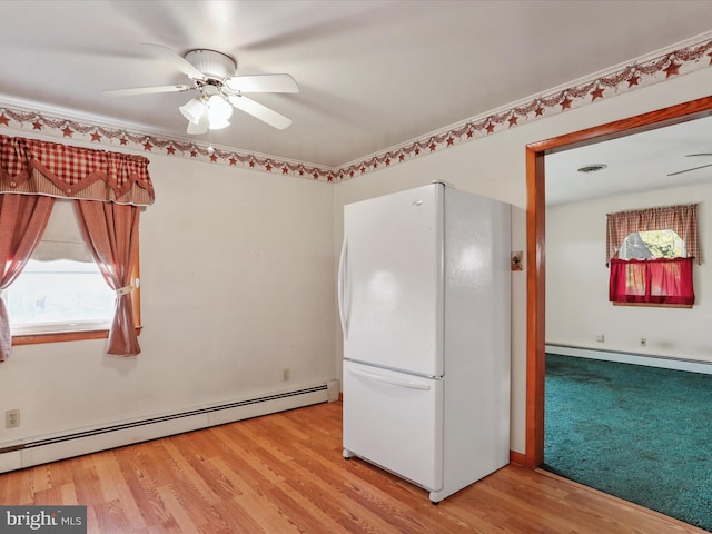 kitchen featuring baseboard heating, ceiling fan, white fridge, and light hardwood / wood-style floors