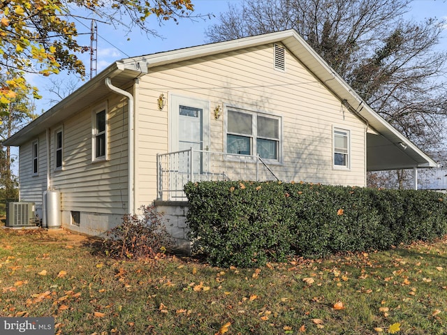 view of home's exterior with a yard and central AC