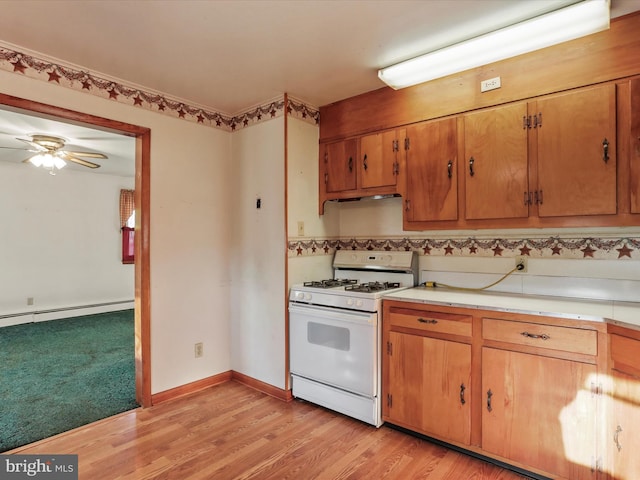 kitchen with light hardwood / wood-style flooring, white range with gas cooktop, a baseboard heating unit, and ceiling fan