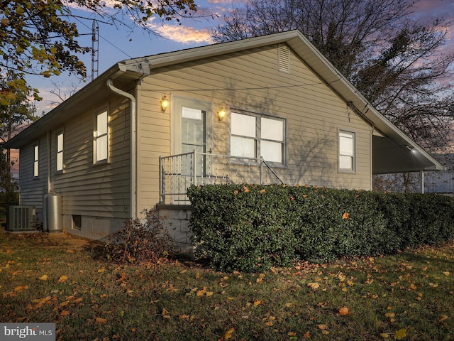 property exterior at dusk with cooling unit