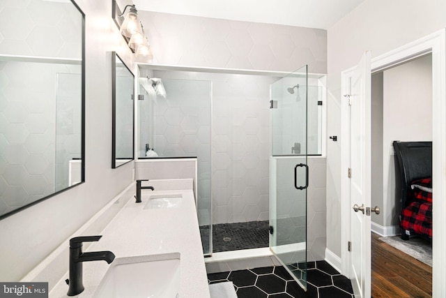 bathroom with hardwood / wood-style floors, vanity, and a shower with door