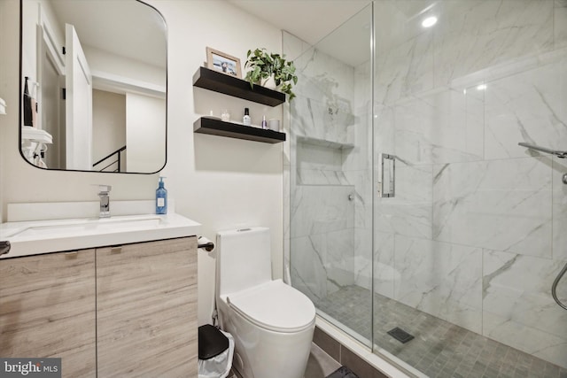 bathroom with vanity, toilet, and a shower with shower door