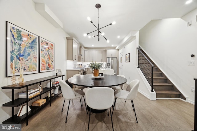 dining space featuring light wood-type flooring and a notable chandelier