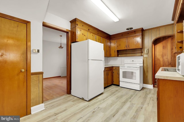 kitchen featuring pendant lighting, white appliances, and light wood-type flooring