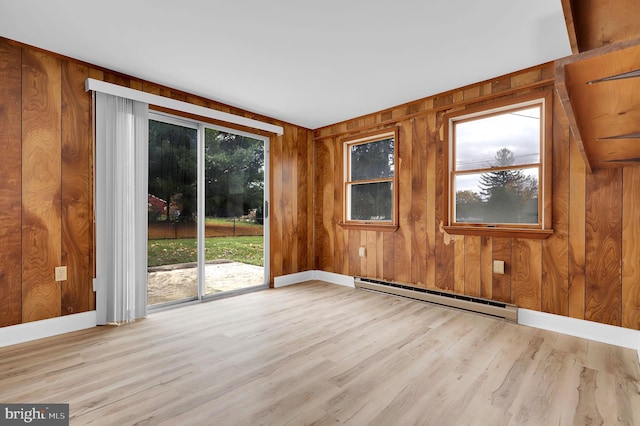 spare room featuring light hardwood / wood-style floors, plenty of natural light, and a baseboard heating unit