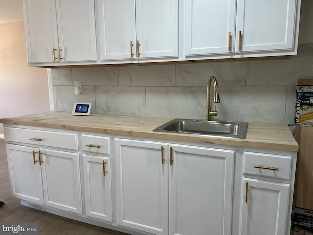 kitchen featuring white cabinets, butcher block counters, dark wood-type flooring, and sink