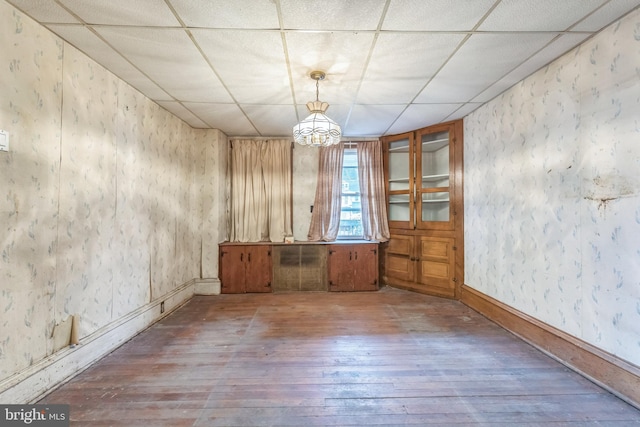 unfurnished room with a drop ceiling and wood-type flooring