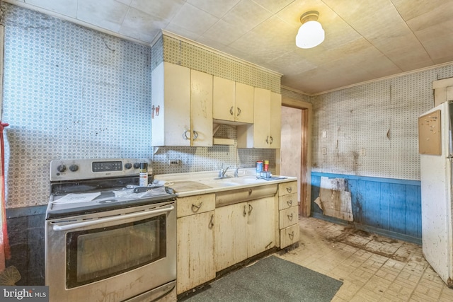 kitchen featuring ornamental molding, sink, cream cabinets, tile walls, and stainless steel electric range oven