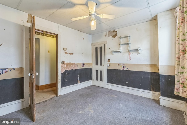 carpeted empty room featuring a paneled ceiling and ceiling fan