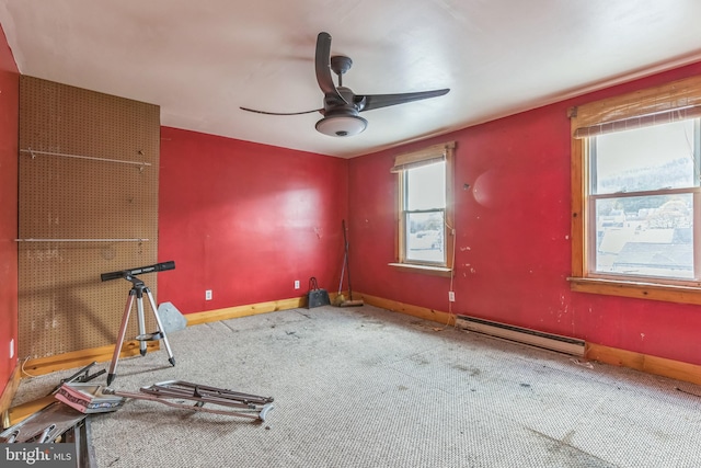 interior space with carpet floors, ceiling fan, and a baseboard heating unit