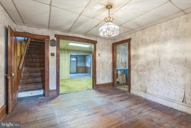 empty room featuring wood-type flooring and a drop ceiling