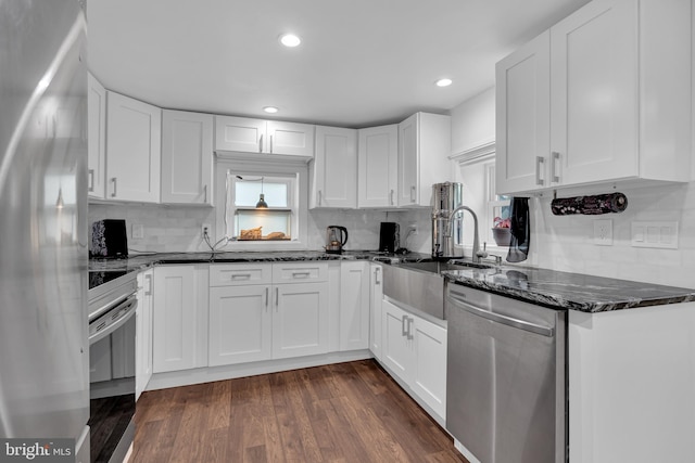 kitchen with dark hardwood / wood-style floors, decorative backsplash, white cabinetry, and appliances with stainless steel finishes