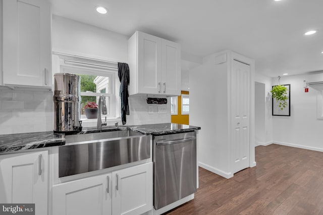 kitchen featuring dark hardwood / wood-style flooring, stainless steel dishwasher, dark stone counters, decorative backsplash, and white cabinets