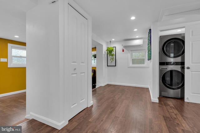 laundry area with a wall mounted air conditioner, stacked washing maching and dryer, and dark hardwood / wood-style floors