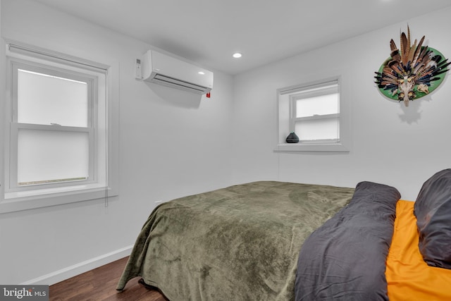 bedroom with dark hardwood / wood-style floors and a wall mounted AC