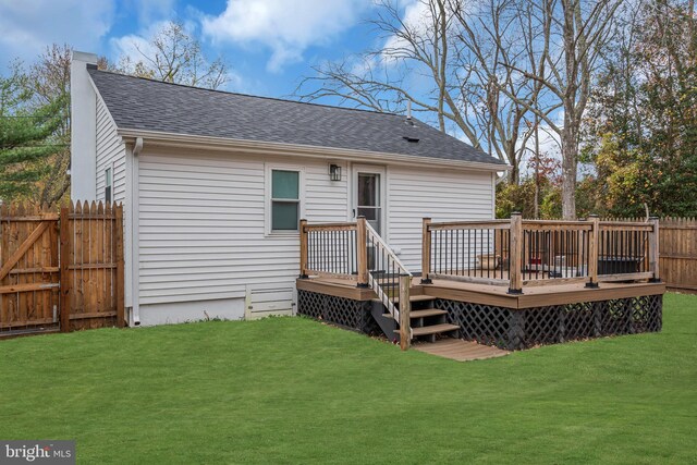 rear view of property with a yard and a wooden deck