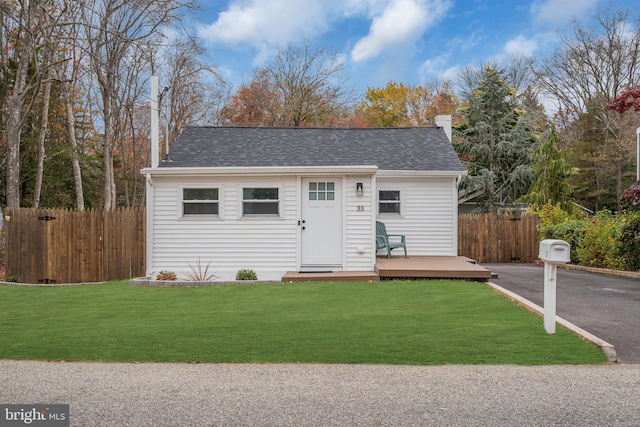 view of front of property featuring a deck and a front yard