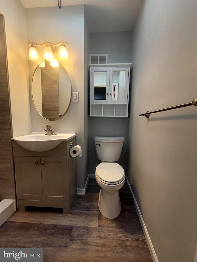 6107 Loretto Ave, Philadelphia, PA 19149 - bathroom featuring wood finished floors, toilet, baseboards, and vanity