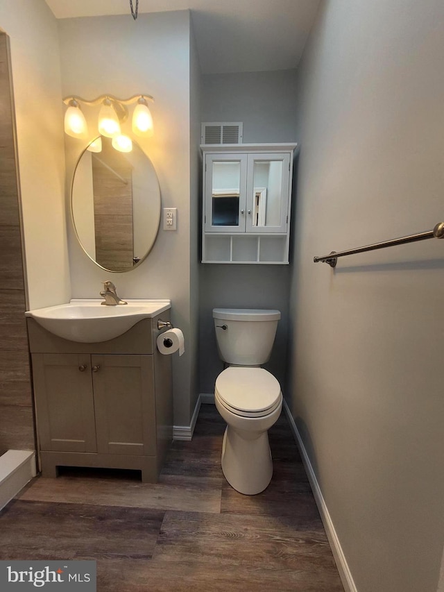 bathroom with hardwood / wood-style floors, vanity, and toilet