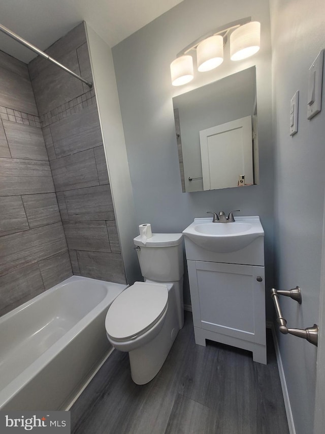 full bathroom with toilet, vanity, hardwood / wood-style flooring, and tiled shower / bath combo