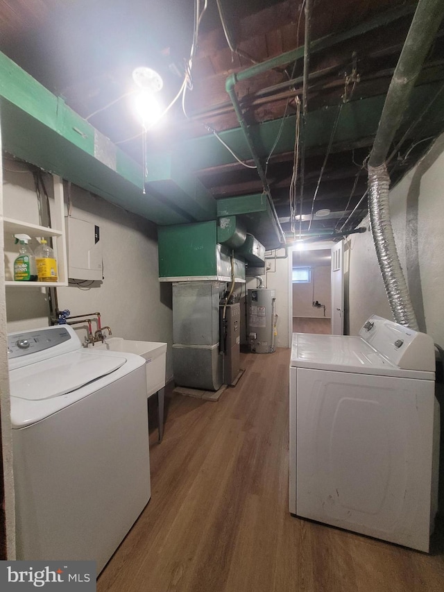 laundry room featuring washer and clothes dryer, gas water heater, wood-type flooring, and heating unit