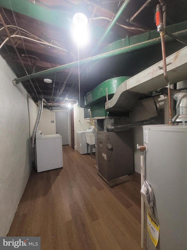 basement with heating unit, washer / clothes dryer, hardwood / wood-style flooring, and water heater