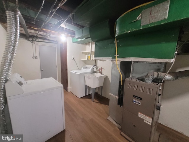 interior space with wood-type flooring, sink, and washing machine and clothes dryer