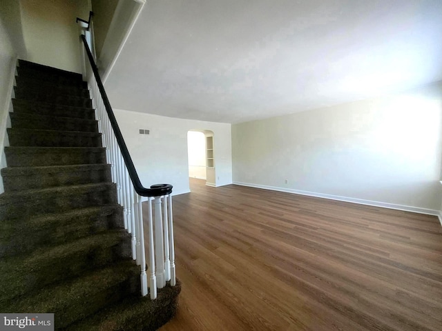 6107 Loretto Ave, Philadelphia, PA 19149 - stairs with arched walkways, wood finished floors, and baseboards
