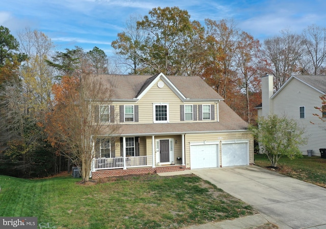 colonial house featuring a front yard, a porch, and a garage