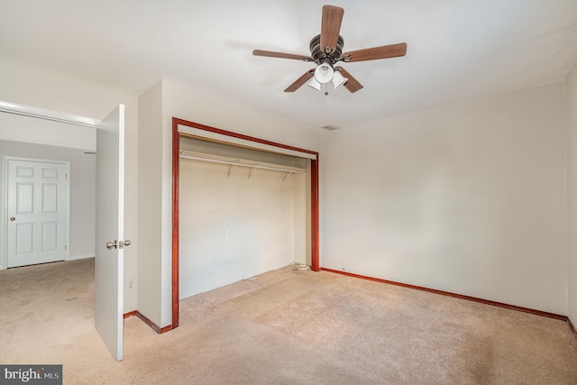 unfurnished bedroom featuring a closet, light colored carpet, and ceiling fan