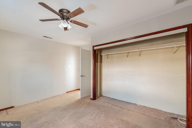 unfurnished bedroom featuring ceiling fan, a closet, and light carpet