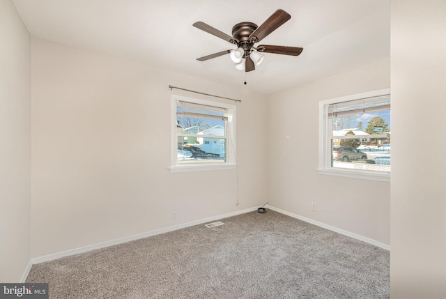 empty room with plenty of natural light, ceiling fan, and light carpet